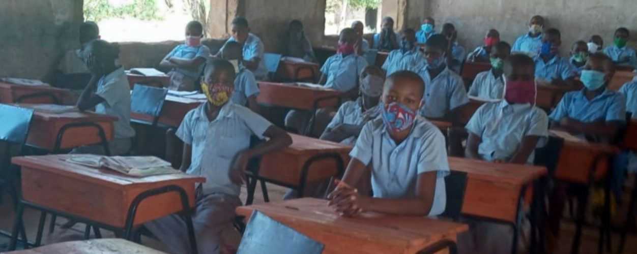 A class of children seated at desks wearing face masks